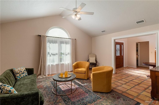 living room with tile patterned floors, ceiling fan, and vaulted ceiling