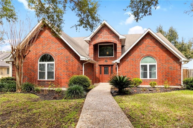 traditional-style house with a front lawn and brick siding