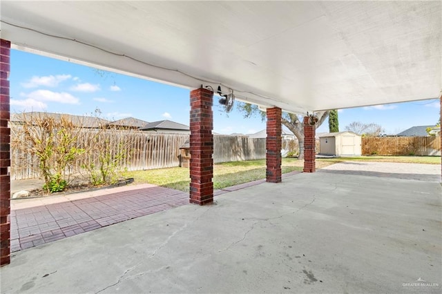 view of patio with a fenced backyard, an outdoor structure, and a storage shed