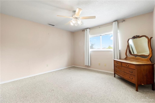 bedroom featuring ceiling fan, a textured ceiling, light carpet, visible vents, and baseboards