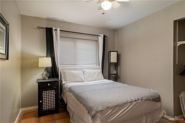 tiled bedroom featuring ceiling fan