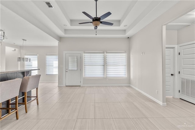 4630 Kristine Dr, Harlingen, TX 78552 - unfurnished living room featuring visible vents, baseboards, a ceiling fan, and a raised ceiling