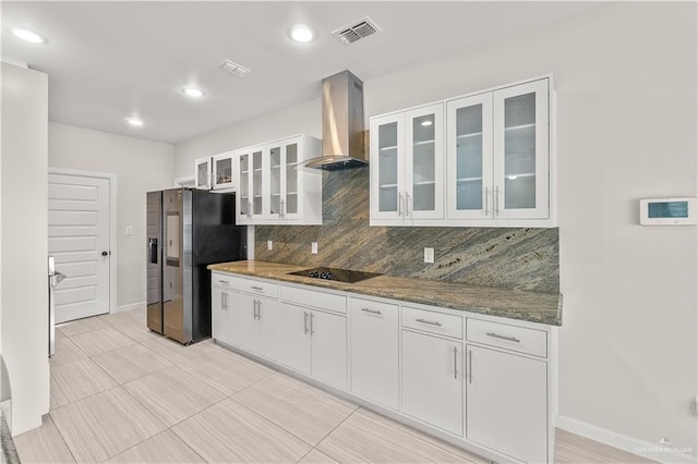 4630 Kristine Dr, Harlingen, TX 78552 - kitchen with tasteful backsplash, stainless steel fridge, wall chimney range hood, visible vents, and black electric cooktop