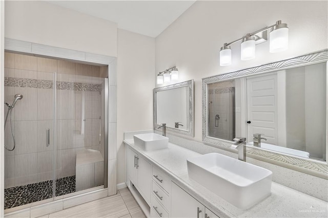 4630 Kristine Dr, Harlingen, TX 78552 - bathroom featuring a shower stall, tile patterned flooring, double vanity, and a sink