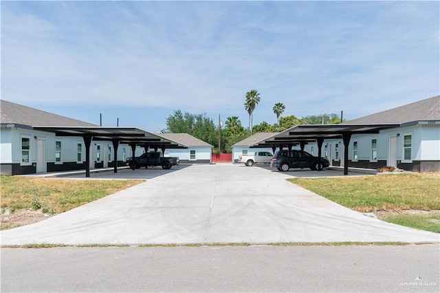 view of car parking with a carport and a yard