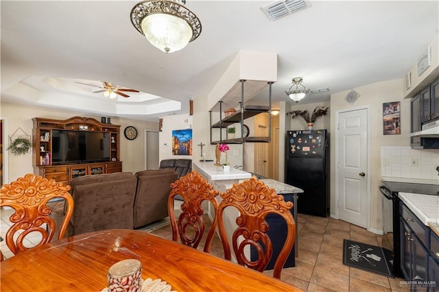 605 W Lozano St, Harlingen, TX 78550 - dining space with ceiling fan, a raised ceiling, and light tile patterned floors