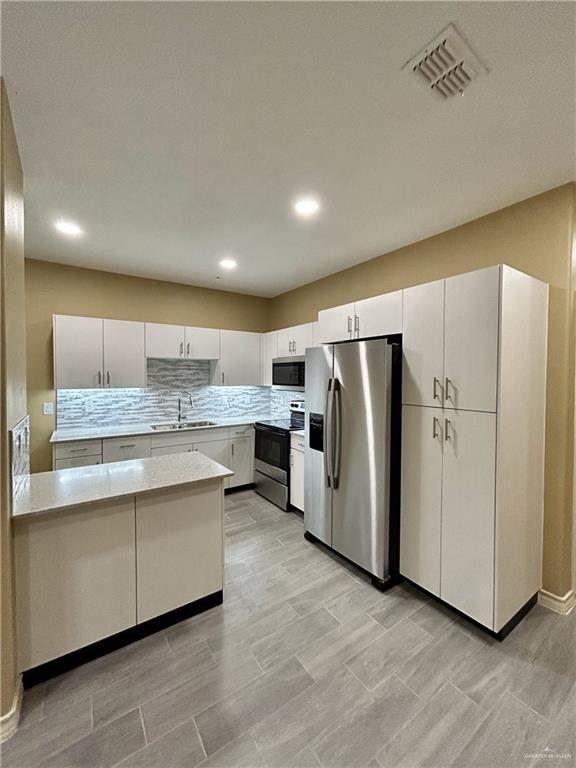 kitchen featuring white cabinetry, sink, and appliances with stainless steel finishes