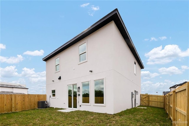 back of house featuring a lawn and central air condition unit