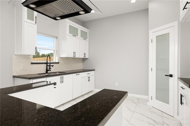 kitchen with range hood, sink, white cabinetry, and tasteful backsplash