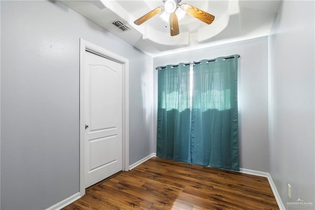 spare room with ceiling fan and dark wood-type flooring