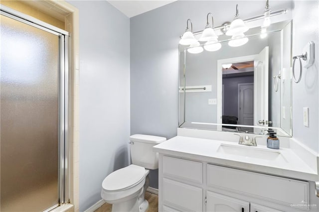 bathroom featuring vanity, toilet, and an enclosed shower