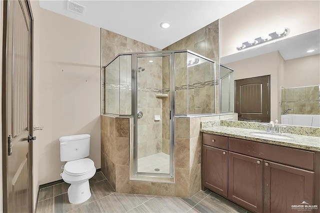 bathroom with tile patterned floors, vanity, toilet, and a shower with door