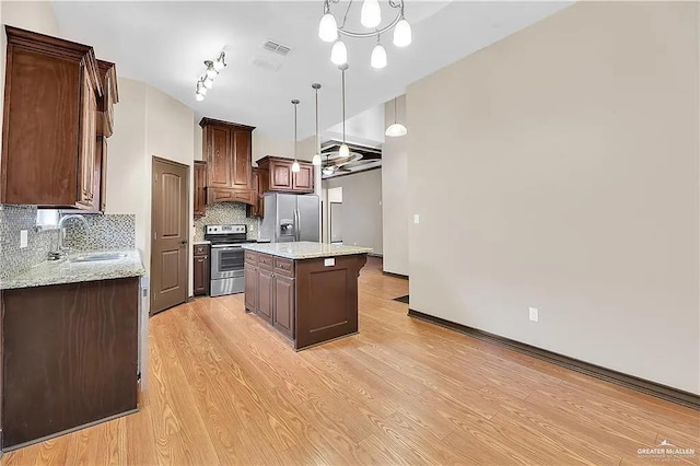 kitchen with decorative light fixtures, sink, a center island, light hardwood / wood-style floors, and stainless steel appliances