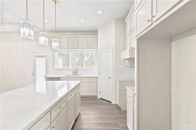 4312 Xenops Ave, Mcallen, TX 78503 - kitchen featuring a sink, wood finish floors, light countertops, decorative light fixtures, and recessed lighting