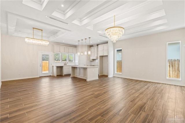 unfurnished living room with sink and an inviting chandelier