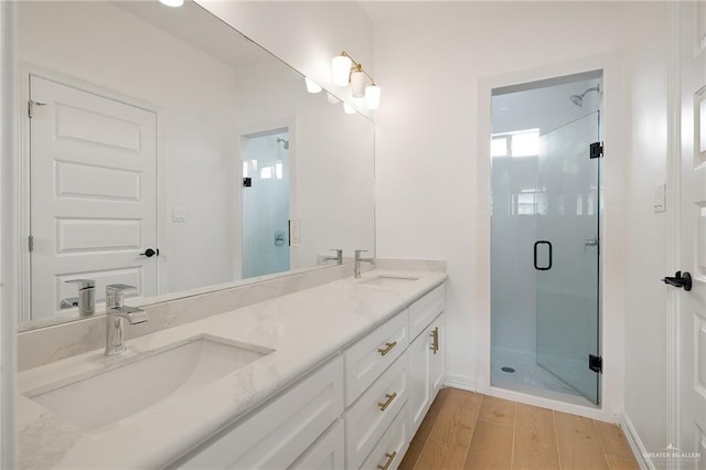 1305 Franklin Ave, Alton, TX 78573 - bathroom with a shower stall, wood finished floors, double vanity, and baseboards