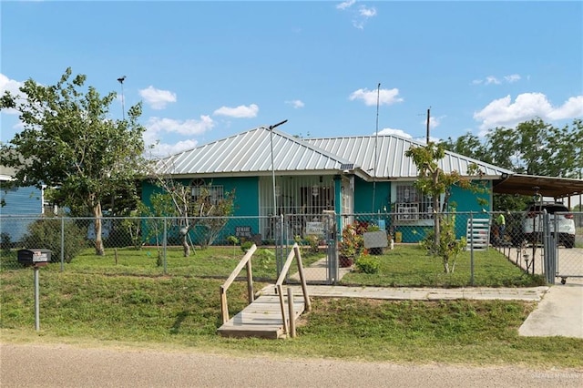 100 W Mesquite St, Sullivan City, TX 78595 - view of front of home with fence private yard, a carport, a front yard, and metal roof