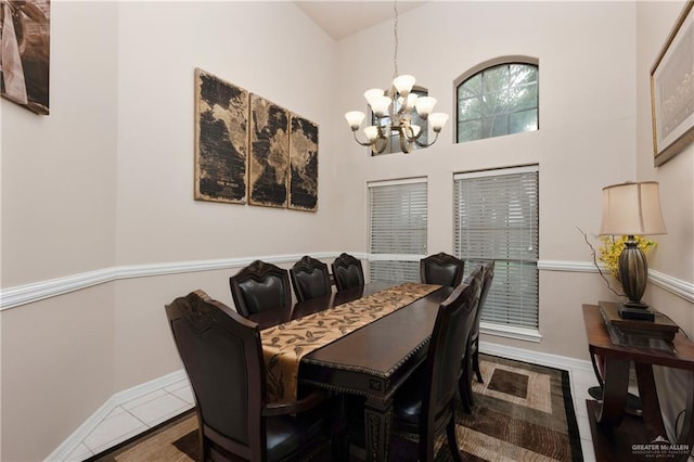 dining space with tile patterned flooring, a high ceiling, and an inviting chandelier