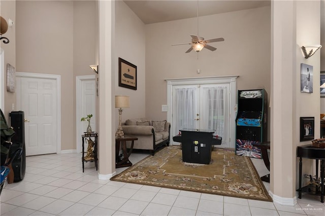 living room featuring ceiling fan, a towering ceiling, and light tile patterned floors