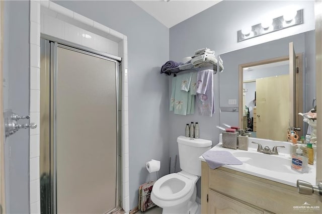 bathroom with vanity, toilet, and a shower with door