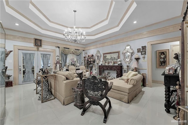 living room featuring french doors, ornamental molding, a notable chandelier, and a tray ceiling