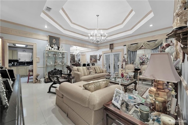 tiled living room with crown molding, a tray ceiling, a chandelier, and french doors