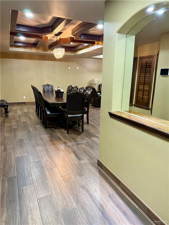 812 W Falcon Ave, Pharr, TX 78577 - dining space featuring arched walkways, a raised ceiling, wood finished floors, and coffered ceiling