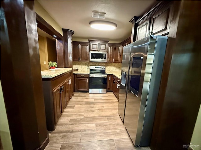 812 W Falcon Ave, Pharr, TX 78577 - kitchen featuring stainless steel appliances, decorative backsplash, dark brown cabinets, light stone countertops, and light wood-style floors