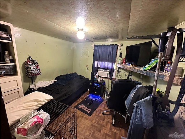 bedroom featuring dark parquet flooring, cooling unit, and a textured ceiling