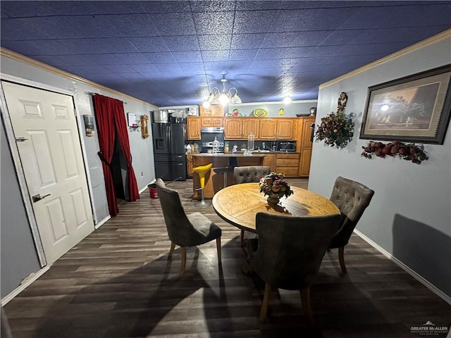 dining area featuring dark hardwood / wood-style floors, ornamental molding, and a chandelier