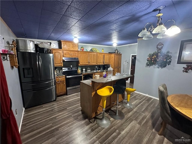 kitchen featuring a breakfast bar, a center island, backsplash, dark hardwood / wood-style flooring, and stainless steel appliances