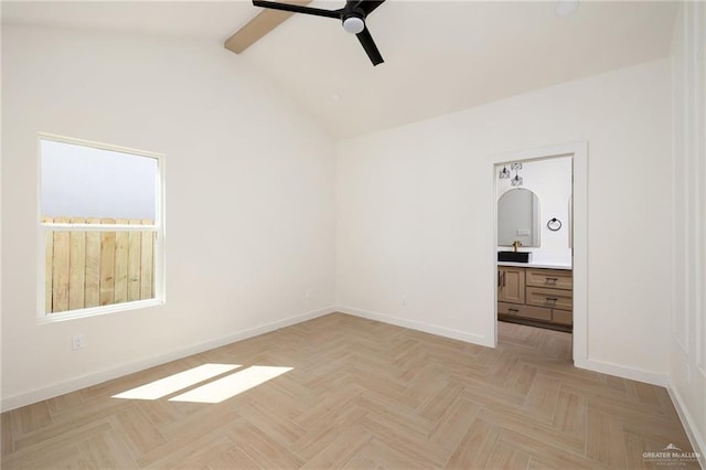 unfurnished bedroom with ceiling fan, light parquet flooring, ensuite bathroom, and lofted ceiling with beams