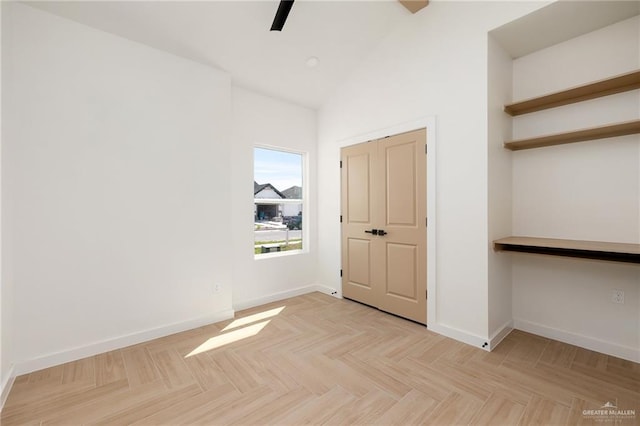 empty room featuring ceiling fan, high vaulted ceiling, and light parquet flooring