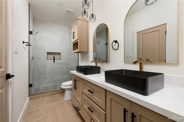 bathroom with vanity, parquet floors, an enclosed shower, and toilet