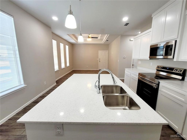 kitchen with white cabinetry, sink, hanging light fixtures, an island with sink, and appliances with stainless steel finishes