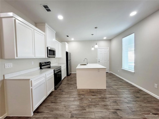 kitchen featuring sink, stainless steel appliances, decorative light fixtures, a kitchen island with sink, and white cabinets