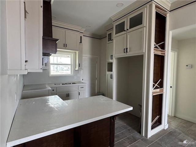 kitchen featuring black cooktop, kitchen peninsula, and white cabinets