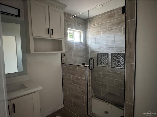 bathroom featuring vanity and a shower with door