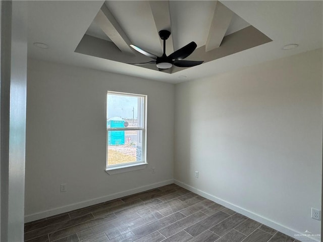 spare room featuring a tray ceiling and ceiling fan