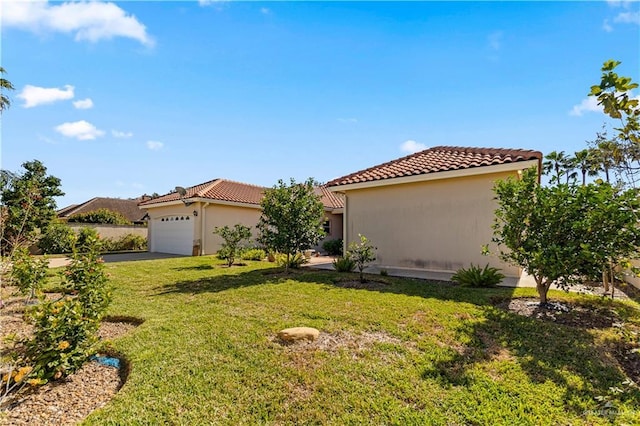 mediterranean / spanish home featuring a garage and a front yard