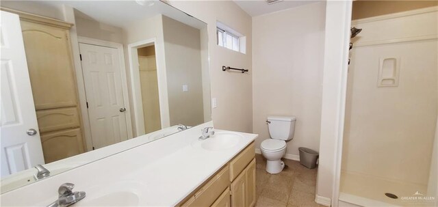 bathroom with walk in shower, vanity, and toilet