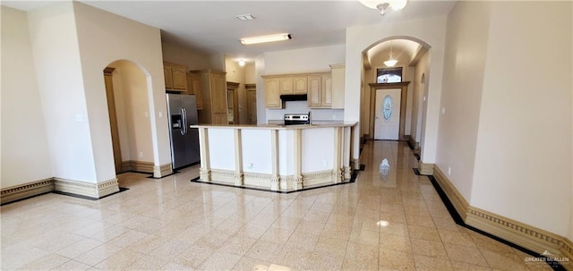 kitchen featuring stainless steel appliances and light brown cabinetry