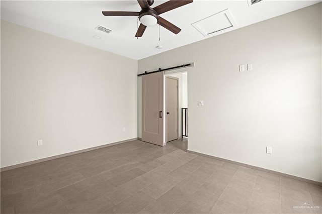 empty room with a barn door and ceiling fan