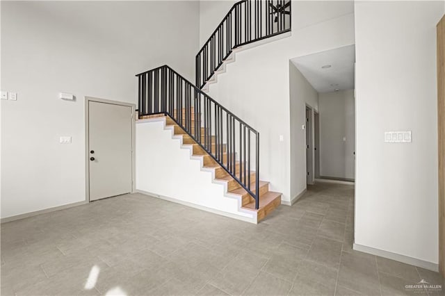 stairs featuring a high ceiling and tile patterned floors