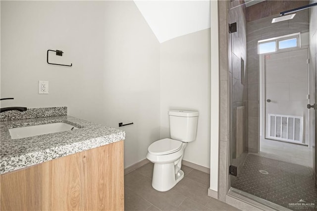 bathroom featuring tile patterned floors, vaulted ceiling, toilet, vanity, and a shower with shower door