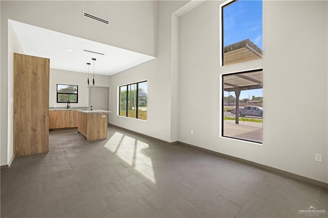 interior space with dark tile patterned flooring, a towering ceiling, and sink