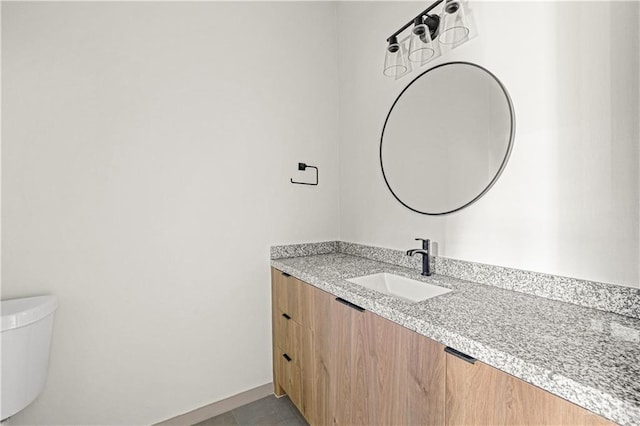 bathroom with tile patterned flooring, vanity, and toilet