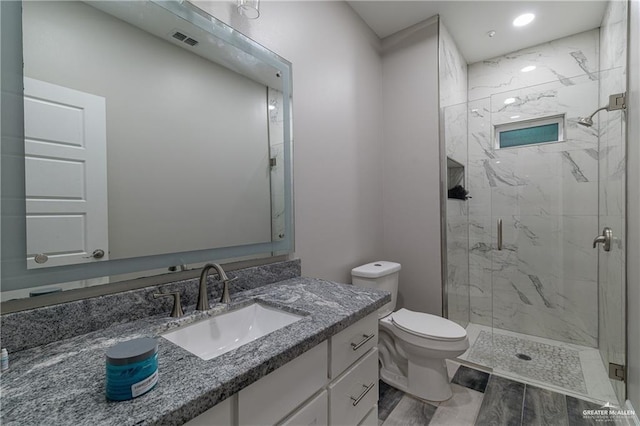 bathroom with vanity, recessed lighting, toilet, a marble finish shower, and visible vents