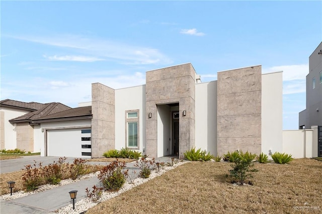 modern home with a garage, stucco siding, and concrete driveway