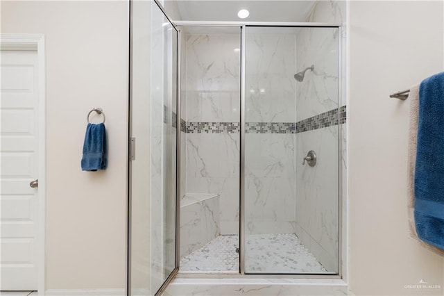bathroom with baseboards and a marble finish shower